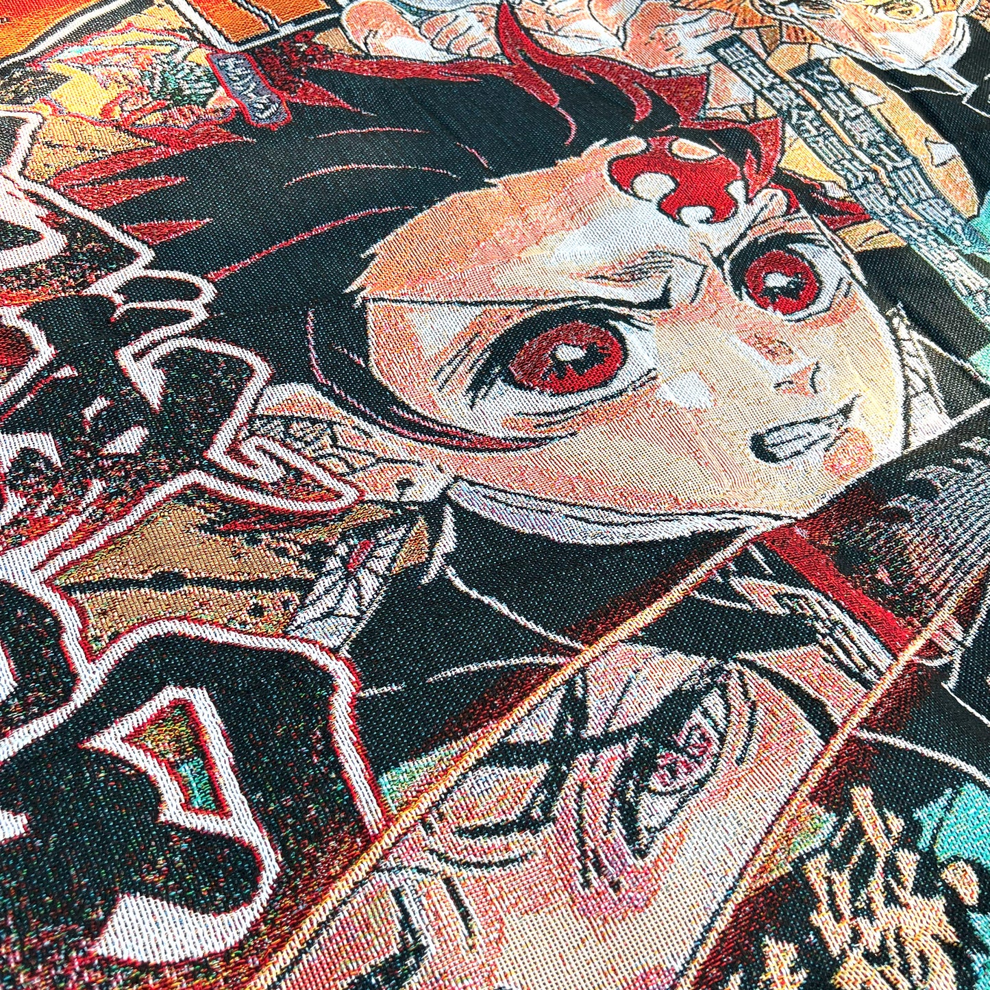 Close-up side view of a Demon Slayer tapestry highlighting detailed textures and vivid colors in the anime-style design.