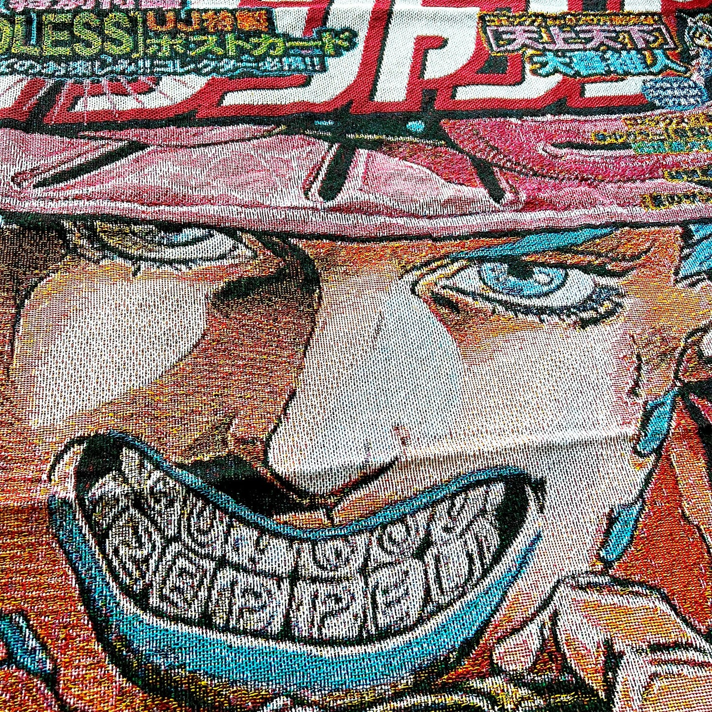 Close-up side view of a Gyro Zeppeli blanket emphasizing vivid artwork and soft, cozy material.